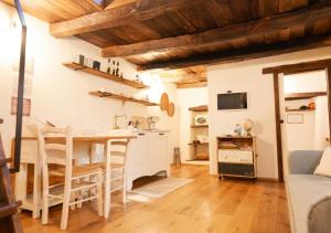 a kitchen with wooden ceilings and a table and chairs at S'Ispera B&B, Home Restaurant, Autentiche Esperienze Sarde in Fonni