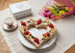 a cake with strawberries in the shape of a heart on a table at S'Ispera B&B, Home Restaurant, Autentiche Esperienze Sarde in Fonni +9 photos