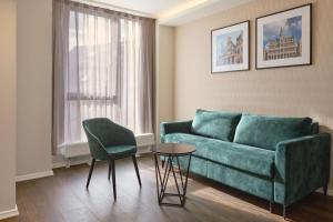 a living room with a green couch and a table at Eurostars Avenue Louise in Brussels