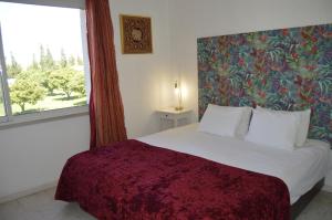 a bedroom with a large bed with a large window at Tavira Vacations Apartments in Tavira +75 photos