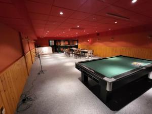 a room with a pool table and a dining room at Négy Évszak Panziò in Siófok