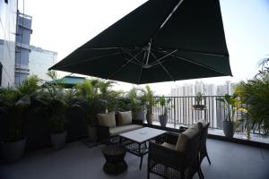 a patio with a table and chairs and an umbrella at The Murti Hotel and Banquet in Noida