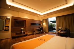 a hotel room with a bed and a television at The Murti Hotel and Banquet in Noida