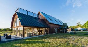 a barn house with a metal roof and glass windows at Bottengarn Boutique Guesthouse - Farm in Igaküla
