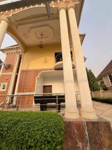 a house with two columns with a piano on the side at Shana Homes in Karsana