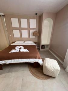 a bedroom with a bed with two towels on it at Studio Tulum - jacuzzi privé - face à la mer in Tartane