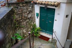 a green door on the side of a stone building at Teatro in Anghiari