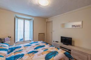 a bedroom with a bed and a flat screen tv at Teatro in Anghiari