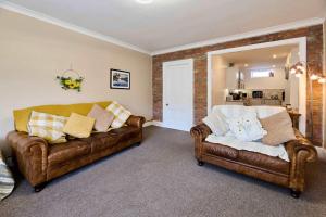 two brown leather couches in a living room at Host & Stay - Llanberis Flat in Llanberis +22 photos