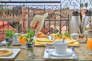 a table with breakfast food on a balcony at Riad ELIZZI in Marrakesh +30 photos