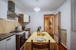 a kitchen with a table with a yellow table cloth at Teatro in Anghiari