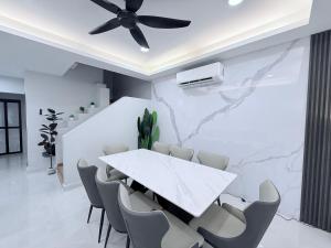 a dining room with a white table and chairs at Marble Manor - Elegant Landed house in Subang Jaya +35 photos