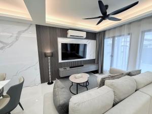 a living room with a couch and a flat screen tv at Marble Manor - Elegant Landed house in Subang Jaya