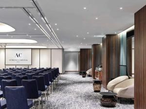 a conference room with rows of chairs and a stage at Athens Capital Center Hotel - MGallery Collection in Athens +279 photos
