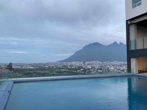 a swimming pool in a building with a view of a city at Puntacero Fundidora 1604 Cintermex in Monterrey