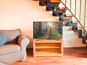 a living room with a tv on a table at SONNENSEITE Schonach - Private Infrarot-Sauna - Schwarzwald-Panoramablick - 2 separate Schlafzimmer - Ruhige Lage am Waldrand in Schonach +33 photos