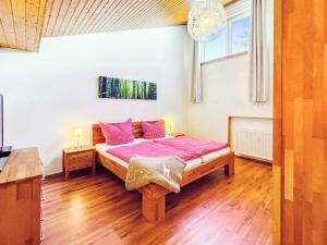 a bedroom with a large bed with pink pillows at SONNENSEITE Schonach - Private Infrarot-Sauna - Schwarzwald-Panoramablick - 2 separate Schlafzimmer - Ruhige Lage am Waldrand in Schonach