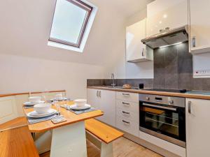 a kitchen with white cabinets and a wooden table at 2 Bed in Woolacombe oc-76350 in Woolacombe