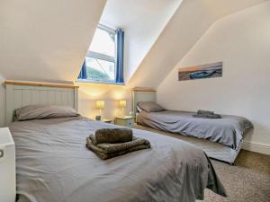 a attic bedroom with two beds and a window at 2 Bed in Woolacombe oc-76350 in Woolacombe