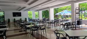 a dining room with tables and chairs and windows at Hotel Sunquest in Venus