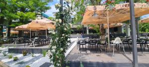 a patio with tables and chairs and umbrellas at Hotel Sunquest in Venus