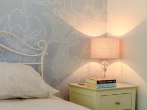 a bedroom with a bed with a lamp and books at 1 Bed in Dorchester oc-dc026 in Broadmayne