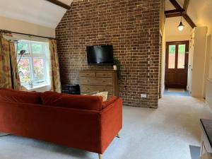 a living room with a couch and a brick wall at 1 Bed in Dorchester oc-dc026 in Broadmayne