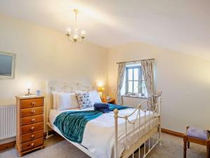 a bedroom with a bed and a dresser and a window at 3 Bed in Tywyn oc-dy021 in Tywyn