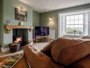 a living room with a couch and a fireplace at 1 Bed in Bideford oc-51784 in Parkham