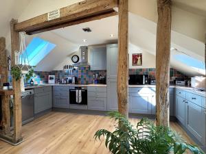 a large kitchen with blue cabinets and wooden floors at 3 Bed in Braunton oc-86704 in Braunton