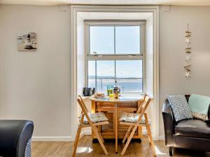 a table and chairs in a room with a window at 2 Bed in Aberdyfi oc-dy044 in Aberdyfi