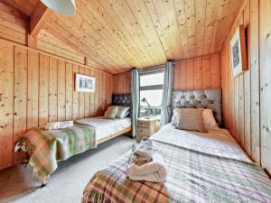 two beds in a room with wooden walls at 2 Bed in Aberdyfi oc-dy050 in Aberdyfi