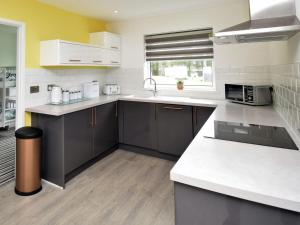 a kitchen with gray cabinets and a white counter top at 2 Bed in Swansea oc-88744 in Knelston