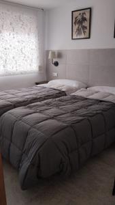 a bedroom with two beds and a window at El Rincón del Olivo in Cartagena