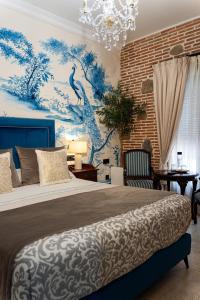 a bedroom with a bed with a blue and white wall at Hotel Boutique Casa Veracruz in Estepona