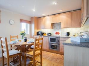 a kitchen with a wooden table and chairs and a table and chairsktop at 2 Bed in Bridport oc-dc015 in West Bay