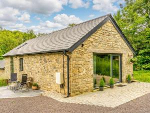 a stone cottage with a large glass window at 2 Bed in Cowbridge oc-88000 in Llandow