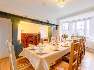 a dining room with a table and a fireplace at 7 Bed in Machynlleth oc-77466 in Aberllefenni