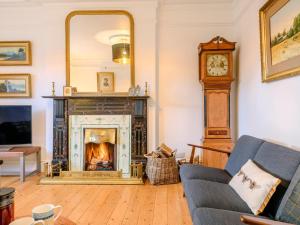a living room with a fireplace and a grandfather clock at 7 Bed in Machynlleth oc-77466 in Aberllefenni