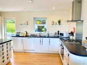 a kitchen with white cabinets and a black counter top at 3 Bed in Shanklin oc-ic113 in Shanklin