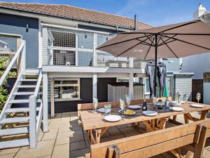 a wooden table with an umbrella on a patio at 4 Bed in Braunton oc-56111 in Croyde