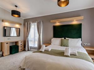 a bedroom with a large bed with a green headboard at 2 Bed in Newport oc-94717 in Nevern