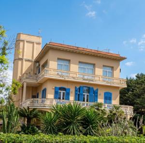 a building with blue windows and a tower at Sirene Blu Mondello in Palermo