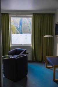 a living room with a couch and a large window at Klingenberg Hotel - Årdal in Årdalstangen
