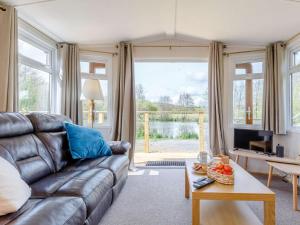 a living room with a leather couch and a television at 2 Bed in South Brent oc-82871 in South Brent