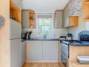 a kitchen with white cabinets and a stove top oven at 2 Bed in South Brent oc-82871 in South Brent +13 photos