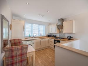 a kitchen with white cabinets and a sink at 2 Bed in Tywyn oc-dy052 in Tywyn
