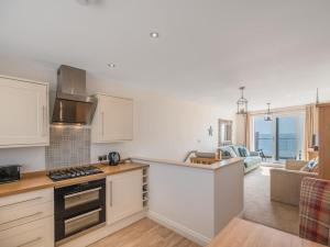 a kitchen with white cabinets and a living room at 2 Bed in Tywyn oc-dy052 in Tywyn