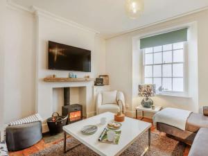 a living room with a table and a fireplace at 4 Bed in Bideford oc-88876 in Appledore