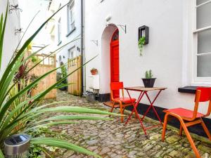 a patio with two chairs and a table and a red door at 4 Bed in Bideford oc-88876 in Appledore